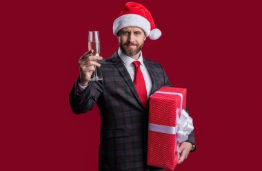 Neşeli Noel işadamı hediyesini kutluyor. Noel Baba şapkalı Noel işadamı. İş adamı bayramı kutluyor. Noel 'i kutlayalım. İşadamı kırmızıda izole edilmiş Noel 'i kutluyor.