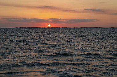Deniz üzerinde bulutlu dramatik bir gökyüzü ya da ufukta gemileri ve romantik manzarası olan inanılmaz bir gün batımı manzarası..