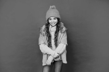 Şapkalı, kıvırcık saçlı neşeli çocuk. Kadın manken. Örgü giyen genç bir kız. Kalın giysiler giyen çocuk portresi. Olumlu duygularını ifade et. kış modası.