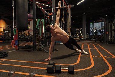 Spor sporcusu spor salonunda yan tahta egzersizi yapıyor. Beden eğitiminde yan tahta egzersizi. Spor ve spor. Spor salonundaki sporcunun kalas egzersizi.