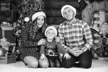 Keşke öyle olsa. Anne, baba ve küçük çocuk partide eğleniyor. Mutlu aile yeni yılı kutluyor. Ailesi ve oğlu Noel Baba şapkası takıyor. Anne ve baba ve çocuk tatillerde evde kalıyorlar. Mutlu Noeller..