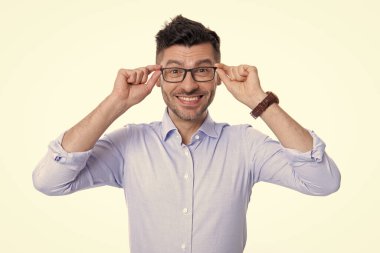 Neşeli erkek gözlüğü takıyor. Gözlüklü neşeli adamın fotoğrafı. Gözlüklü neşeli adam beyaz arka planda izole edilmiş. Stüdyoda gözlük takan neşeli adam..