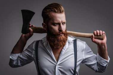 Retro tarzı. Yakışıklı ve karizmatik. Erkeksi adam. Baltası gri renkte olan sakallı bir adamın erkekliği. Sakallı ve bıyıklı, beyaz, vahşi bir adam. Erkeksi enerji. Retro berber dükkanı.