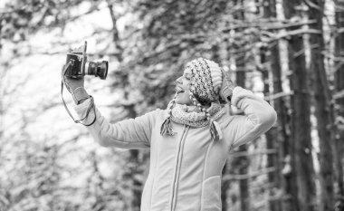 Kış eğlencesi. Mutlu kadın kamerada selfie çekiyor. Kış özçekimi. Karlı ormanlarda eğleniyoruz. Soğuk hava iyi ruh hali getirir. Hava tahmini için hazırız. Keşif gezisi. Klasik kameralı kışlık kız..