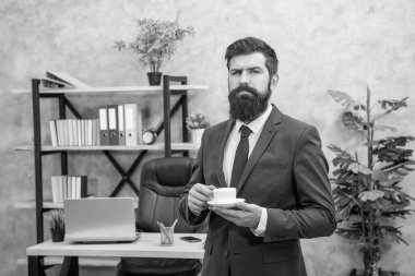 İş adamı kılığındaki acımasız CEO ofiste kahve fincanıyla öğle yemeği molası veriyor..