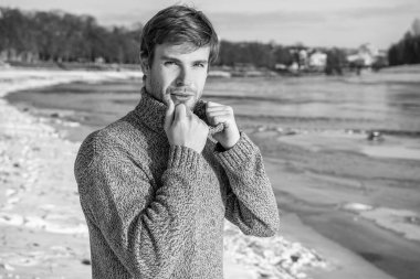 Açık havada sıradan bir kazak giyen adam. Açık havada kışın süveter giyen şık bir adam. Tatillerde kazaklı bir adam. Erkekler kış süveteri giyer.