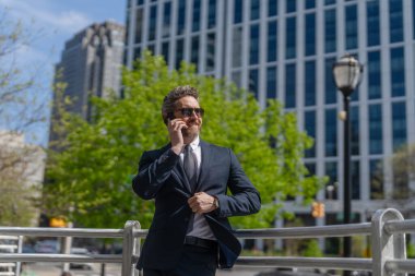 İş adamının dışarıyı araması gerekiyor. Telefon kullanan bir iş adamı. Takım elbiseli bir adam telefonda konuşuyor. Telefonu olan orta yaşlı İspanyol işadamı. İş iletişimi. Ortak iletişim..