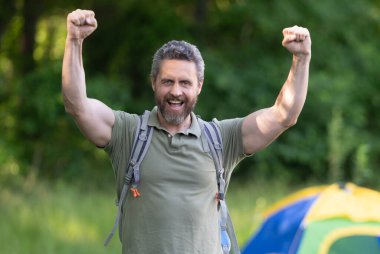 Yaz kampındaki adam. Kamp macerası. Yürüyüş konsepti. Kamp çadırı. Ormanda çadırda çadırda bir adam var. Bir yaz günü doğa yürüyüşçüsü. Yaz kampı ve mutlu doğa tatili. Amerikan Turizmi.