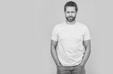 Sıradan bir adam stüdyoda üzerinde fotokopi afişi olan sarı bir tişört giyer. Sarı tişört giyen bir adamın fotoğrafı. Erkekler sarı tişört giyer. Adam arka planda sarı tişört giyiyor..