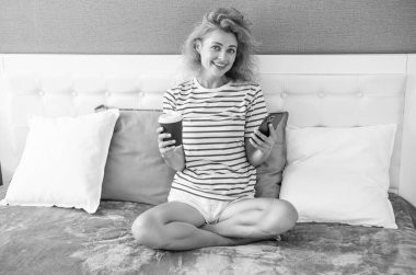 Kahveli neşeli kadının telefonda iletişimi var. Evde telefonla kadın iletişimi. Kadının evindeki telefon görüşmeleri.