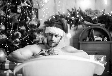 Kendimi şımartıyorum. Tatiller rahatlatır. Noel turu konsepti. Küvette yatan adam hediye kutusuyla rahatlar. Seksi maço, küvette rahatlıyor. Spa ve sağlık. Yeni yıl kutlamalarının tadını çıkar. Kitap otelde kalır..