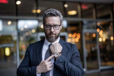 Zaman yönetimi. Dakik adam nöbette parmağıyla işaret ediyor. Nöbetçi bir iş adamı. Dakik iş adamı dışarıda zamanı kontrol ediyor. İş için son gün. İşadamı son teslim tarihine geç kaldı.