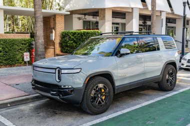 Miami Beach, Florida USA - June 9, 2024: Rivian R1S Adventure Quad Motor at miami beach. Rivian R1S light grey blue clipart