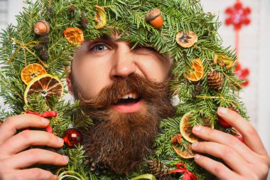 Xmas ev dekorasyonu. Madalyalı Noel adamı. Noel 'de sakallı adam. Yeni yıl tatili. Bıyıklı adam Xmas çelengini tutuyor. - Mutlu yıllar. Noel çelengi portresi. Bayram kutlamaları..