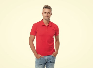 Beyaz arka planda, kırmızı tişörtlü, kır saçlı yakışıklı bir adam..