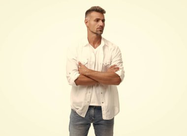 Beyaz arka planda izole edilmiş karizmatik, olgun, kır saçlı bir adam. Beyaz gömlekli, kır saçlı bir adam. Boz adam tarzı. Grimli adamın stüdyo çekimi.