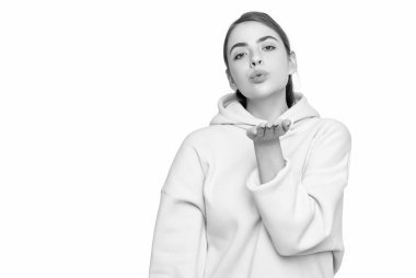 young girl in pink hoodie isolated on white background. blow kiss.