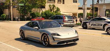 Fort Lauderdale, Florida, USA - March 25, 2023: 2020 Porsche Taycan Turbo electric car on the road, corner view. clipart