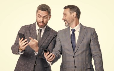 İş adamları telefon kullanır. Mesajlaşan iki işadamı e-postaları kontrol ediyor. Telefondaki mesajları okuyan iş adamları beyazdan izole edilmiş. İş mesajlaşması. İnternet üzerinden iş mesajlaşması. Mesaj bildirimi.