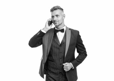 smiling man in tuxedo speaking on smartphone isolated on white background.