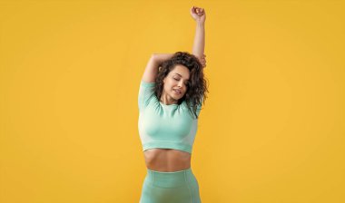 Atletik kadın kol germe atölyesinde çalışıyor. Sarıda izole edilmiş aktif bir kadın. Spor ve spor. Egzersiz ve fiziksel uygunluk.