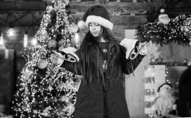 Noel aktivitesi. Buz pateni. Mutlu noeller. Mutlu çocukluk kavramı. Mucize zamanı. Çocuk Noel Baba şapkası. Noel Baba hediye getirmiş. Mutluluk ve neşe. Çocuk mutlu bir kız Noel ağacı bulur..