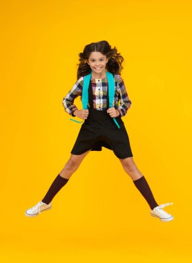 Sırt çantasıyla atlayan öğrenci kız. Okula dönelim. Bilgi toplama günü. Bilgi ve eğitim. Okul eğitimi. Mutlu öğrenci. Sarıda izole edilmiş mutlu bir kız. 1 Eylül. Üniversitede okuyorum..