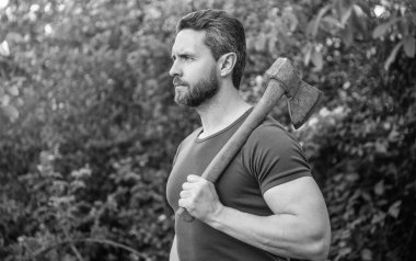 Elinde balta olan beyaz bir adam. Baltalı adam tişört giyiyor. Elinde balta olan bir adam. Baltalı adamın fotoğrafı..