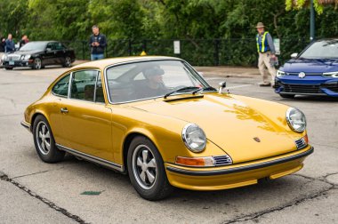 Chicago, Illinois - September 29, 2024: 1972 Porsche 911T Coupe on the road. gold metallic 1972 Porsche 911T Coupe. clipart