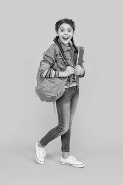 Sarı arka plan, okul, şok olmuş kız öğrenci. Ergen kız okula geri döndü. 1 Eylül. Okul eğitimi.