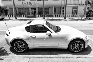 Miami Beach, Florida USA - April 14, 2021: white mazda mx 5 or Miata 1989 roadster, side view. classic sport car. clipart