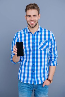 Ürünü sunuyorum. İş uygulamasının reklamı. Milenyum iş adamı telefon ekranını sunuyor. İş adamı Grey 'de izole edilmiş bir telefon gösteriyor. Yeni telefon uygulaması gösteren bir adam.