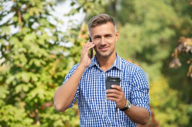 İş adamı CEO 'su dışarıda akıllı telefondan konuşuyor. Olgun iş adamı telefon görüşmesi yapar. İş görüşmesi. Adam akıllı telefonda konuşuyor. Telefon var. Mobil iletişim. Kahve molası. İletişim.