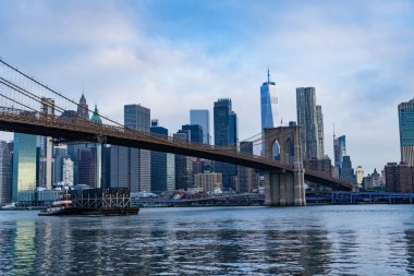 Brooklyn Köprüsü 'nün New York' taki gökdelenin üzerindeki manzarası inanılmaz. Brooklyn 'deki tarihi köprünün mimarisi. Manhattan 'a kadar. New York 'taki Brooklyn Köprüsü. Manhattan şehir manzarası. Mavna ve römorkör..