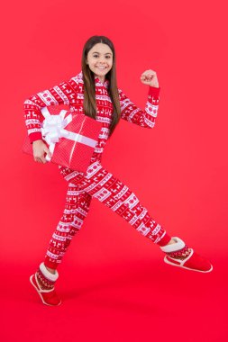 Yeni yıl. Kırmızı yeni yılı olan gülümseyen genç kız stüdyoda. Genç kız yeni yılı kırmızı arkaplanda tek başına çalışarak geçirdi..