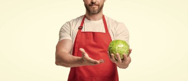 Önlüklü bir adamın beyaz üzerinde taze lahana sebzesi olan görüntüsü..