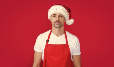 Kırmızı barmen önlüklü ve Noel Baba şapkalı gerçek bir olgun adam..