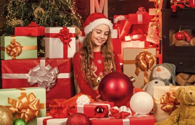 Mutlu noeller. Mutlu çocukluk kavramı. Çocuk Noel Baba şapkası hediye kutuları. Noel Baba bana hediyeler getirdi. Hediyelik eşya dükkanı. Büyüleyici ve samimi. Mutluluk ve neşe. Çocuk mutlu kız Noel ağacının yanında hediye bulur..