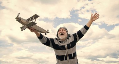 happy senior man high on sky background. senior man at retirement. senior retired man with toy plane outdoor.