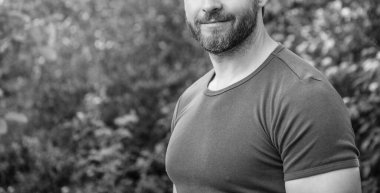 Tişörtlü adamın kırpılmış görüntüsü. Sakallı, beyaz bir adam. Olgun adam dışarıda. Boşluğu kopyala.