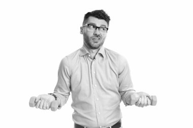 Doubtful man holding fitness dumbbells studio. Dumbbell workout. Fitness with dumbbells. Fitness and exercise. Fitness workout.