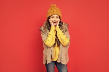 Kırmızı arka planda örülü kış şapkalı genç kız, örgü giyer..