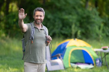 Bir yaz günü doğa yürüyüşçüsü. Yaz kampı ve doğa tatili. Yaz kampındaki adam. Kamp macerası. Yürüyüş konsepti. Kamp çadırı. Ormanda çadırda çadırda bir adam var. Açık hava macerası.