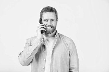 Gülümseyen Adam 'ın stüdyo arka planında izole bir telefon görüşmesi var. Stüdyodaki iletişimi olan adam. İnsanoğlunun iletişim çağrısı. İletişim kuran adamın fotoğrafı..