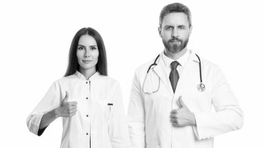 Tıp, sağlık ve insan konsepti. Hastanede pratisyen hekim. Başparmağımı gösteriyorum. Kendine güvenen pratisyen doktor muayenehanede duruyor. Steteskoplu pratisyen hekim.