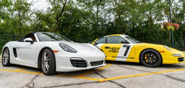 Chicago, Illinois - 29 Eylül 2024: Porsche 911 Carrera S sarı rengi. Porsche 911 Carrera S ve Porsche Boxter 'ın üstü açık arabası sokağa park edilmiş.