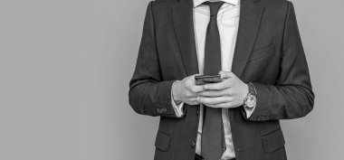 Stüdyoda erkek telefonu konuşması. Telefonu olan genç bir iş adamı. İş iletişimi. Gri yolda izole bir şekilde telefonda sohbet eden sıradan bir iş adamı. Telefon kullanan bir iş adamı. Boşluk afişini kopyala.