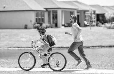 Baba oğul açık havada. Baba ve oğul bisiklet sürmekten zevk alıyorlar. Birlikte pedal çeviriyoruz. Aktif oğul ve baba ikilisi bisiklete biniyor. Baba oğluna bisiklet sürmeyi öğretiyor..