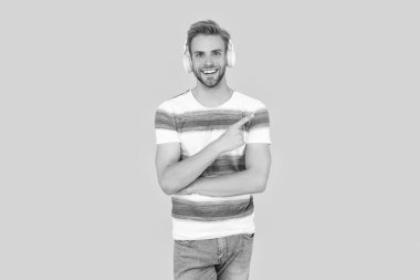 Gülümseyen genç adam çevrimiçi bir derse katılıyor. Kulaklık takan yapılı bir adam. Esmer adam çevrimiçi olarak stüdyoda ders alıyor. Esmer adam sarı arka planda izole edilmiş kulaklık kullanıyor..