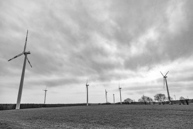 Kırsal bölgedeki yel değirmeni. Deniz aşırı rüzgar parkı. Rüzgar Türbinleri Çiftliği. Alternatif yenilenebilir enerji üretimi. Yeşil enerji kavramı. Yenilenebilir elektrik üretimi için rüzgar değirmeni. Yel değirmeni elektriği.